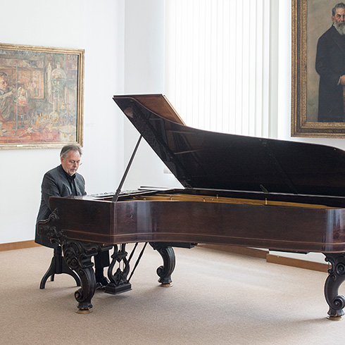 Günther Wess, der selbst auch Musiker ist, spielt hier an Helmholtz’ Flügel, der heute im Deutschen Museum in München steht. Bild: Günther Wess